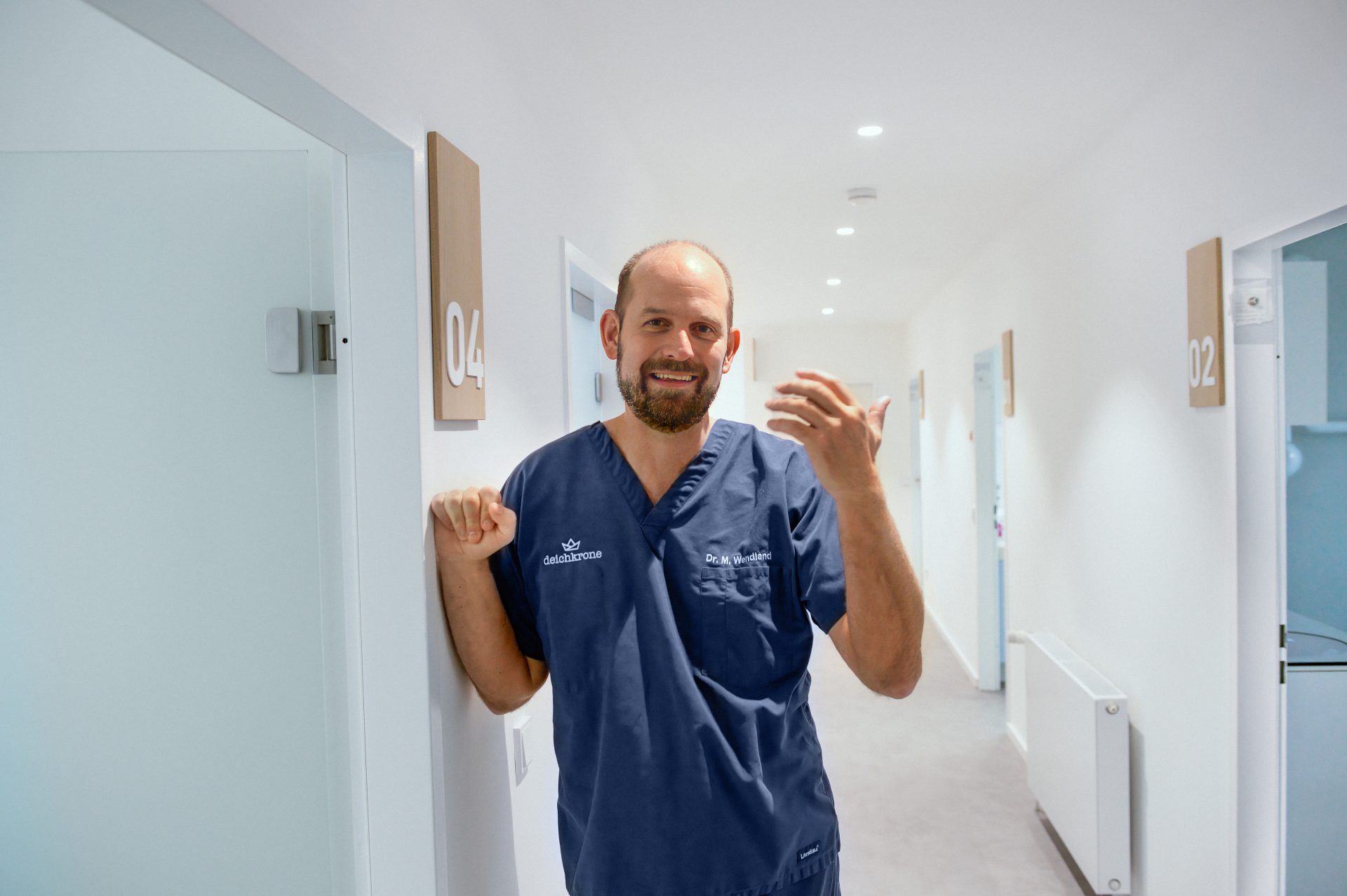 Lächelnder Fachzahnarzt für Oralchirurgie im Flur der Praxis Zahnzentrum Deichkrone
